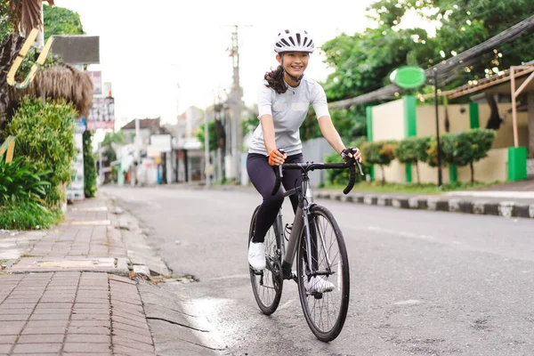 Asiática ciclista feminina em roupas esportivas e capacete — Fotografia de Stock