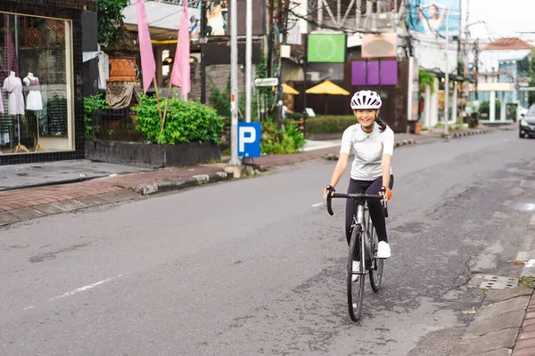 Mujer ciclista asiática en ropa deportiva y casco —  Fotos de Stock