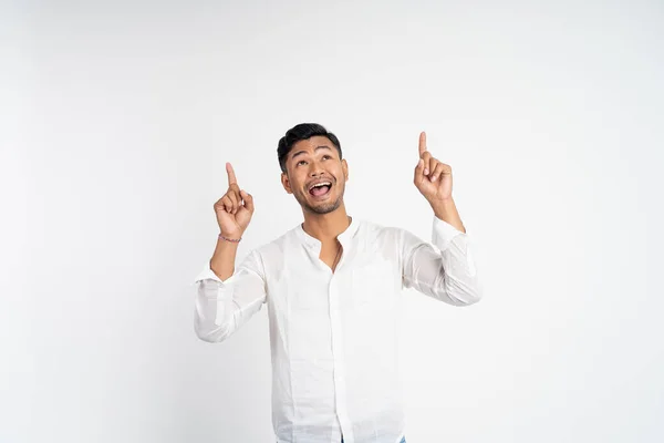 Vzrušený asijský mladý muž se dvěma prsty ukazuje nahoru — Stock fotografie