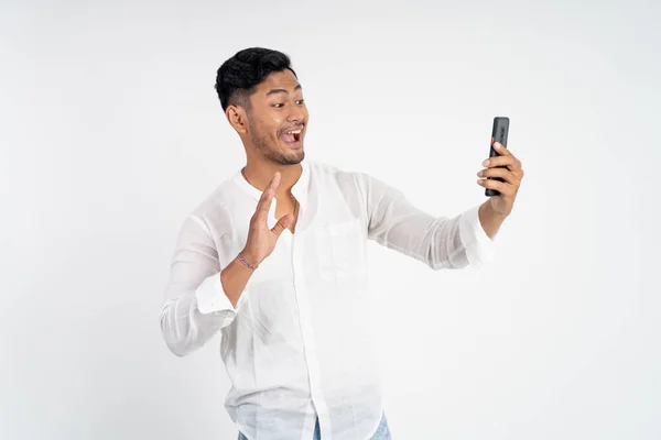 Aufgeregter junger Mann macht Videoanruf und winkt mit einer Hand — Stockfoto