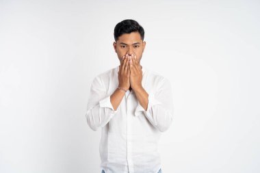 İki eli ağzı kapalı, rahatsız edici bir suratı olan adam.