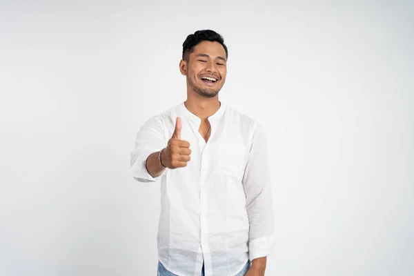 Azji młody człowiek w białej koszuli z kciuki w górę — Zdjęcie stockowe