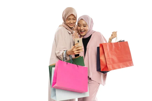 이 시안 히잡 여자 친구가 쇼핑백에 휴대 전화를 사용하여 자화상을 찍고 있다 — 스톡 사진