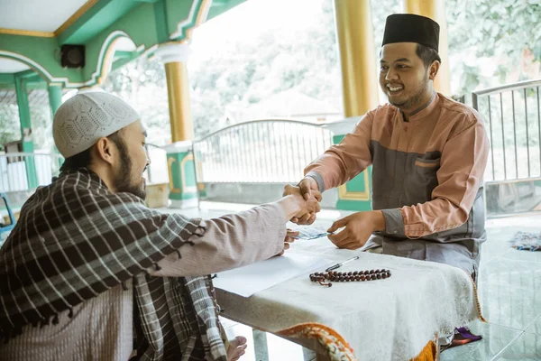 Muslim man shake hand after giving donation and zakat at the mosque — Stock Photo, Image