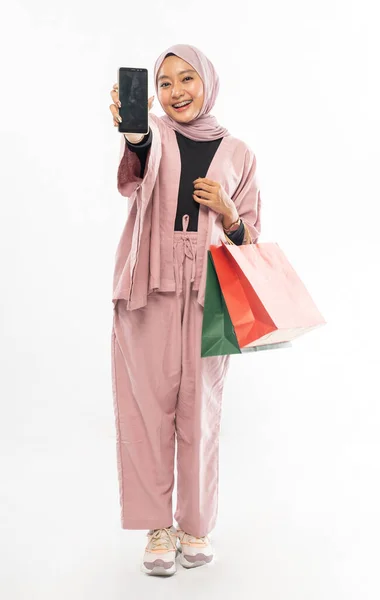 Μουσουλμάνα γυναίκα με hijab ψώνια, ενώ δείχνει το κινητό της τηλέφωνο — Φωτογραφία Αρχείου