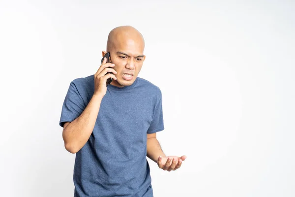 Serious asian bald man listening while calling — Stock Photo, Image