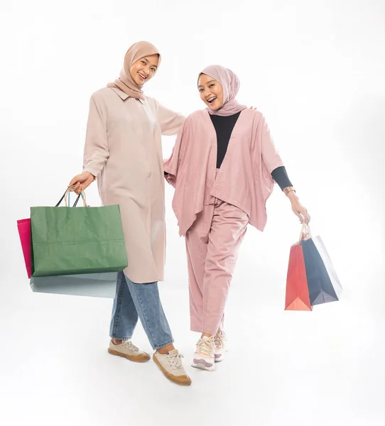 Muslimische Bestfreundin hält glücklich eine Einkaufstasche über weißem Hintergrund — Stockfoto
