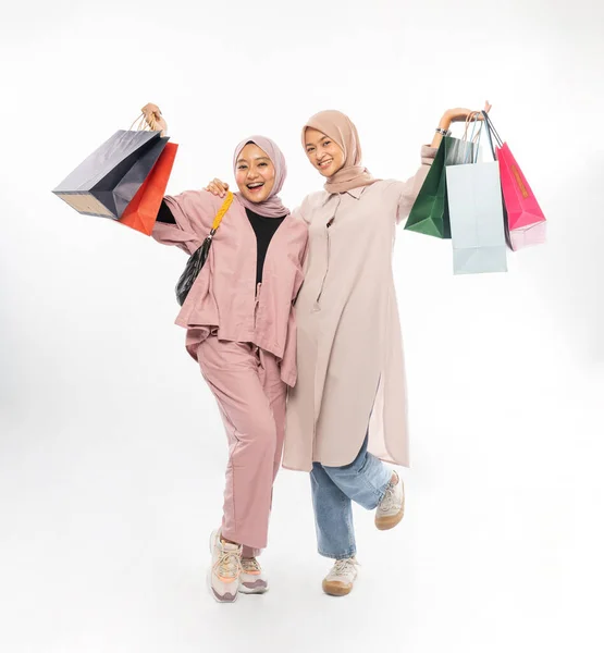 Muslim bästa vän glad att hålla en shoppingpåse över vit bakgrund — Stockfoto