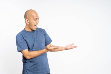 Asyalı kel adam iki eliyle bir şey gösteriyor.