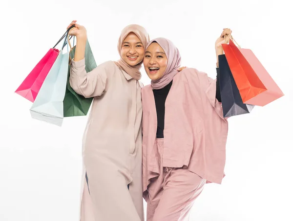 Müslüman en iyi arkadaş beyaz arka planda alışveriş torbası taşımaktan mutlu. — Stok fotoğraf