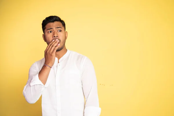 Азиатский мужчина в белой рубашке удивлен ладонями покрывающий рот — стоковое фото