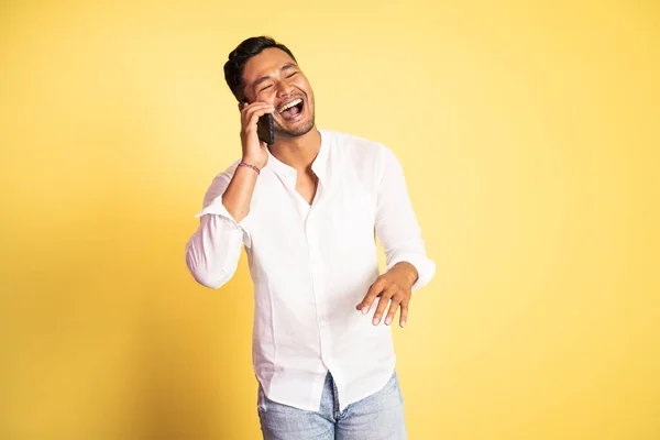 Joven asiático hombre riendo mientras haciendo llamada telefónica — Foto de Stock