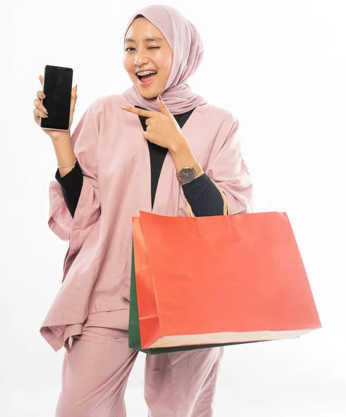 Donna musulmana con hijab shopping mentre mostra il suo telefono cellulare — Foto Stock