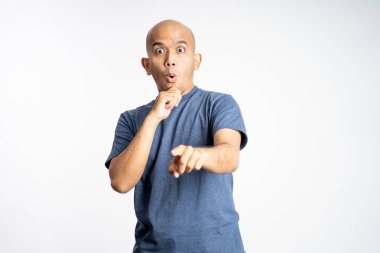 Ağzını tutup işaret eden Asyalı kel adam.