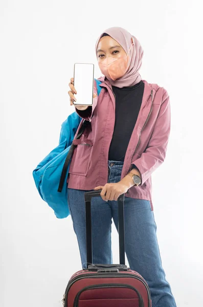 アジア系の女性がスーツケースを持って携帯電話を持ち — ストック写真