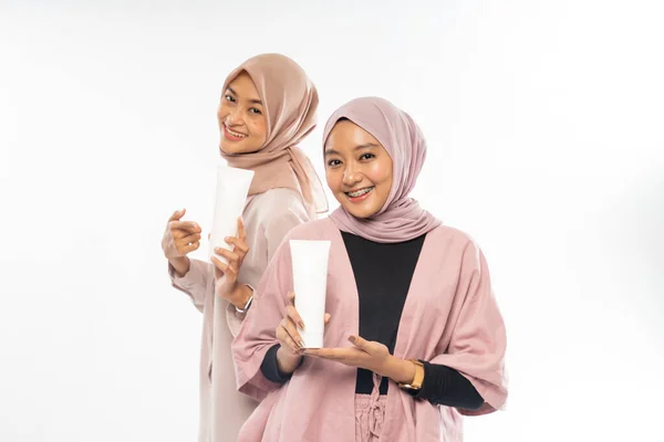 Two muslim beauty friend holding a tube cosmetic product for skincare — Stock Photo, Image