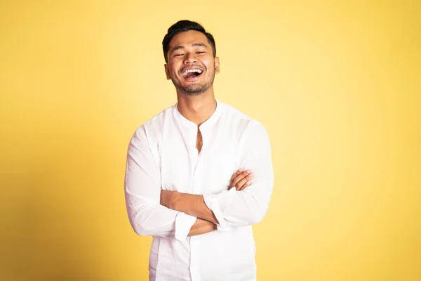 Asijský mladý muž na sobě bílé tričko smích s rukama přes — Stock fotografie
