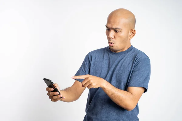 Skallig man förvånad när man tittar på en mobiltelefon — Stockfoto