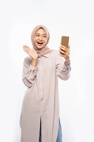 Mulher asiática em hijab segurando um telefone inteligente para selfie — Fotografia de Stock