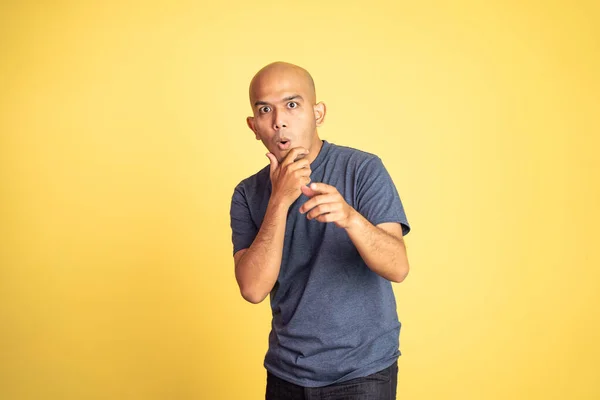 Amazed asian bald man with hand holding mouth and pointing — Stock Photo, Image