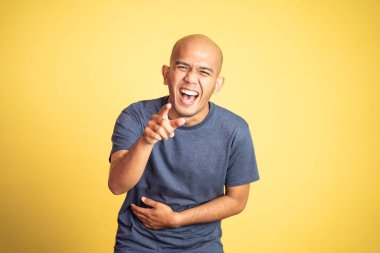 Kamerayı işaret eden gülen Asyalı kel adam.