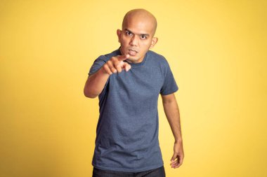 Kamerayı işaret eden kızgın kel bir adam.