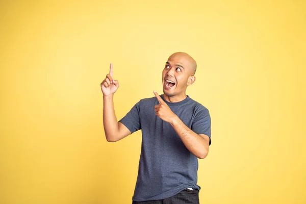 Excitado homem careca com dois dedos apontando para cima — Fotografia de Stock
