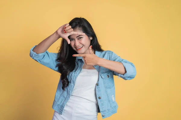 Jonge vrouw kijken van tussen vingers vormen een frame — Stockfoto