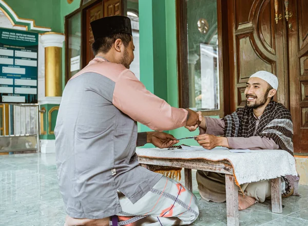 El hombre musulmán se da la mano después de donar y zakat en la mezquita —  Fotos de Stock