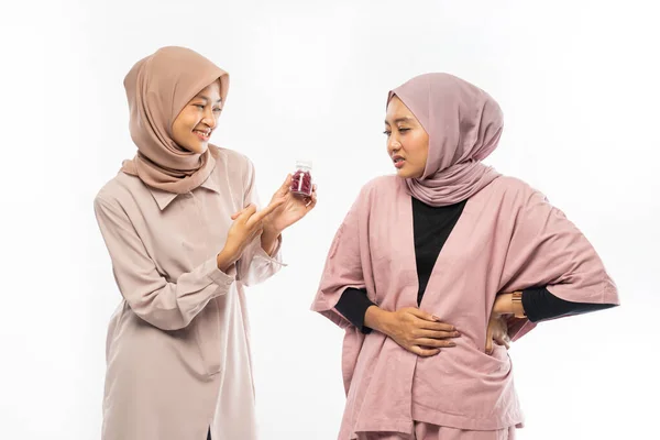 Sian žena muslim v bolesti břicha a přítel doporučující lék — Stock fotografie