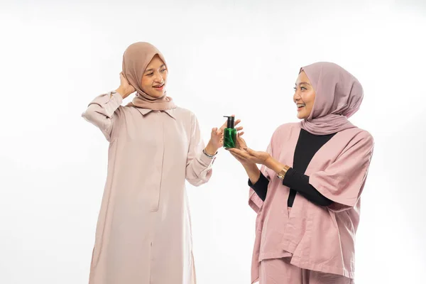 Muslim friend recommending a product to her friend — ストック写真