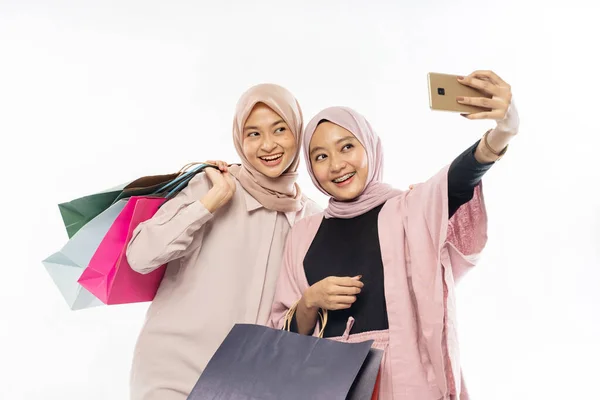 Asian hijab woman friend take self portrait using mobile phone with shopping bag — Stock Photo, Image