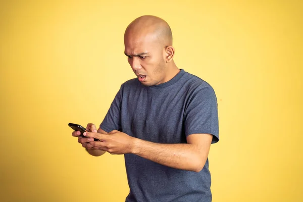 Asyalı kel adam akıllı telefona bakıyor. — Stok fotoğraf