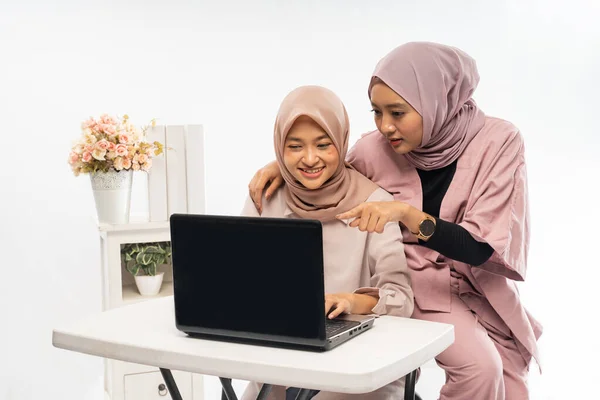 女性穆斯林，头戴头巾，一起在笔记本电脑上工作 — 图库照片