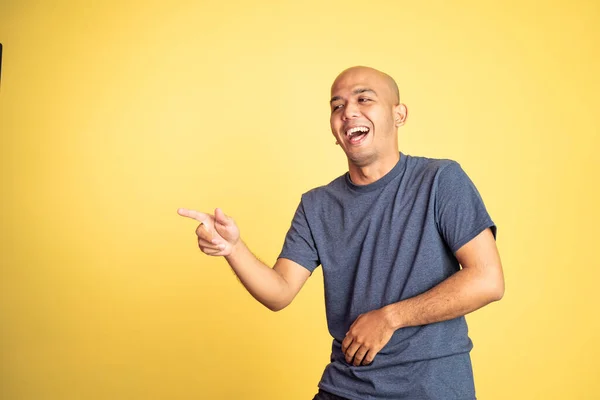 Сміється азіатський лисий чоловік з пальцем, що вказує на камеру — стокове фото