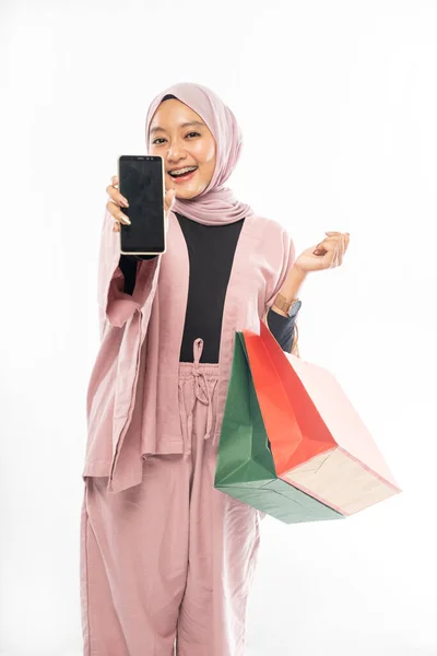 Mulher muçulmana com hijab compras ao mostrar seu telefone móvel — Fotografia de Stock