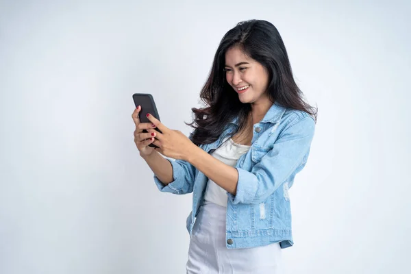 Jonge aziatische vrouw met behulp van mobiele telefoon typen sms-bericht — Stockfoto