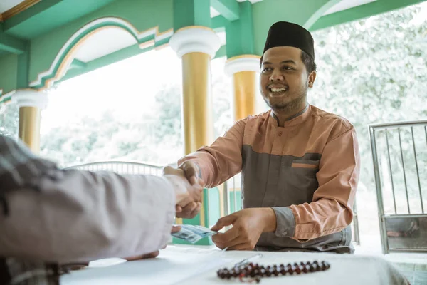 Muslim berjabat tangan setelah memberikan sumbangan dan zakat di masjid — Stok Foto