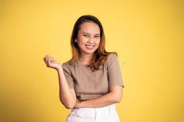 Asyalı güzel gülüşlü bir kadın izole bir arka planda duruyor.