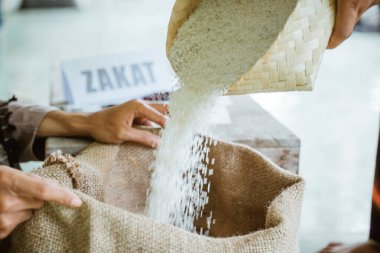 Eller, yoksullara yardım etmek için pirinç taneleri veriyor.