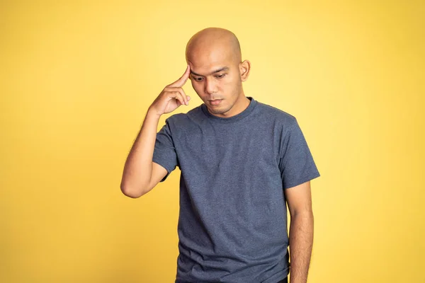 Asiático calvo hombre pensando duro con dedo apuntando a la frente — Foto de Stock