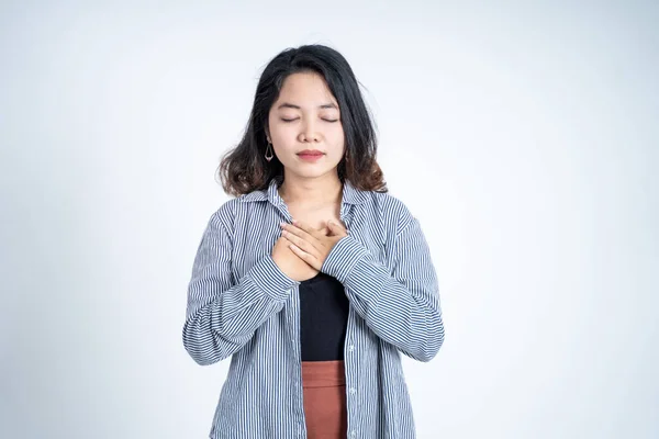 Asiático jovem mulher segurando peito enquanto se sente aliviado — Fotografia de Stock