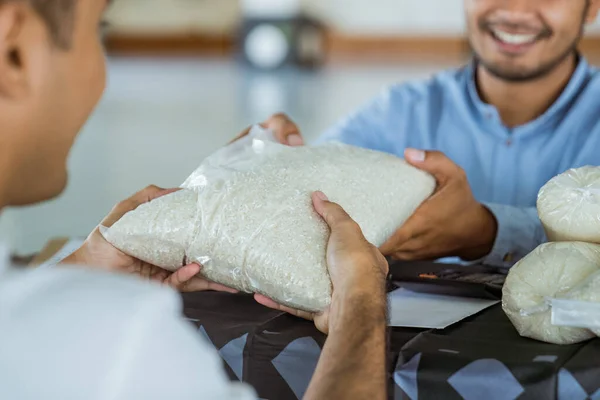 Homem muçulmano dando um arroz como uma doação de alimentos para zakat durante eid mubarak — Fotografia de Stock