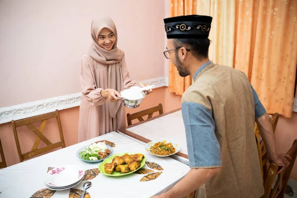 Ibu muslim melayani beberapa makanan untuk makan malam keluarga — Stok Foto