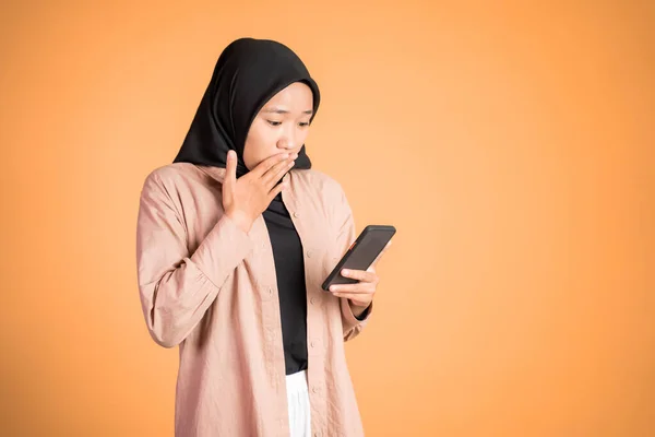 Шокированная мусульманка в хиджабе с помощью мобильного телефона — стоковое фото