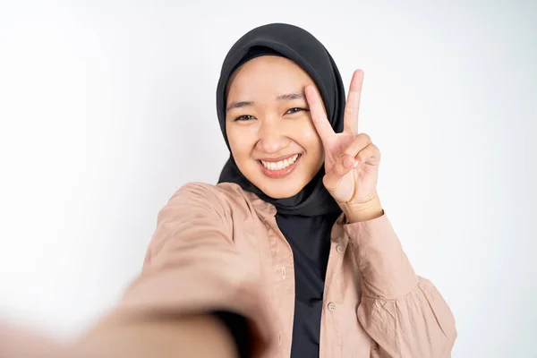 Frau im Hidschab hält Smartphone für Selfie in der Hand — Stockfoto
