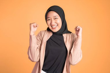 Tesettürlü kadın başarıyı kutlarken ellerini sıkıyor.