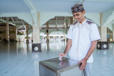Müslümanlar camide para kullanarak sadaka veriyor.