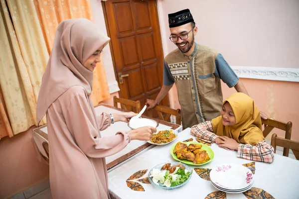 Müslüman anne aile yemeği için yemek servisi yapıyor. — Stok fotoğraf