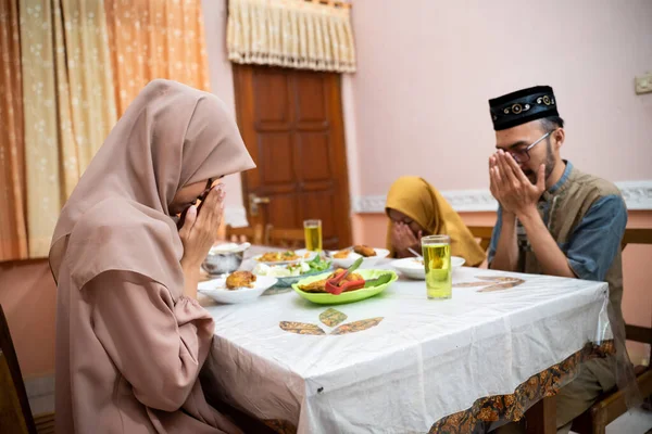 Мусульманская семья молится и благодарит Бога за пищу, прерывая пост — стоковое фото